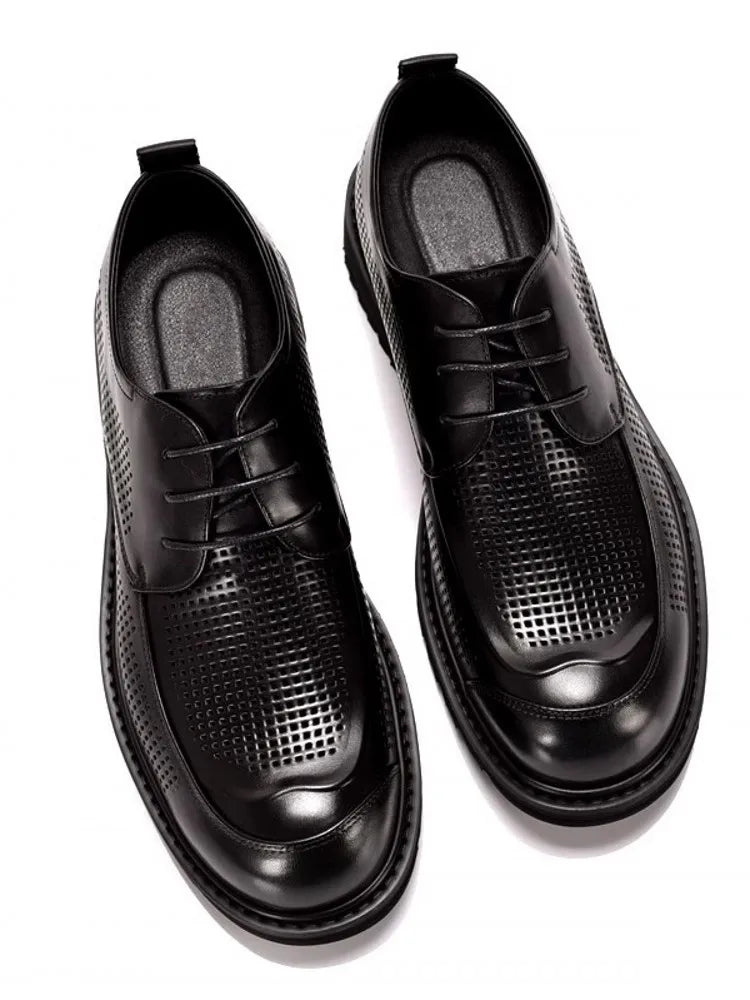 Black leather shoes with textured sole on a white background