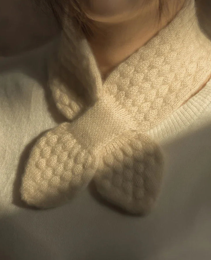 Close-up of beige knitted socks with textured sole on a neutral background