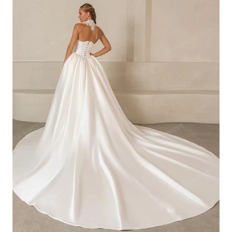 White strapless bridal gown with lace bodice and long draped satin skirt with train.