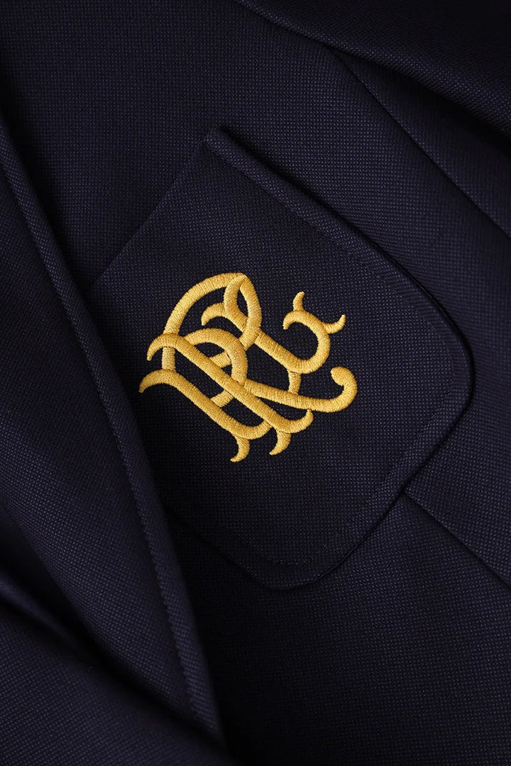 Navy blazer chest pocket with gold embroidered crest design
