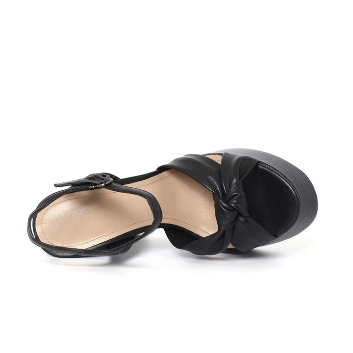 Black heeled sandal underside view, platform sole and buckle strap detail
