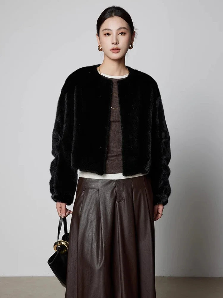 Black short mink fur coat with button front, worn over a satin skirt
