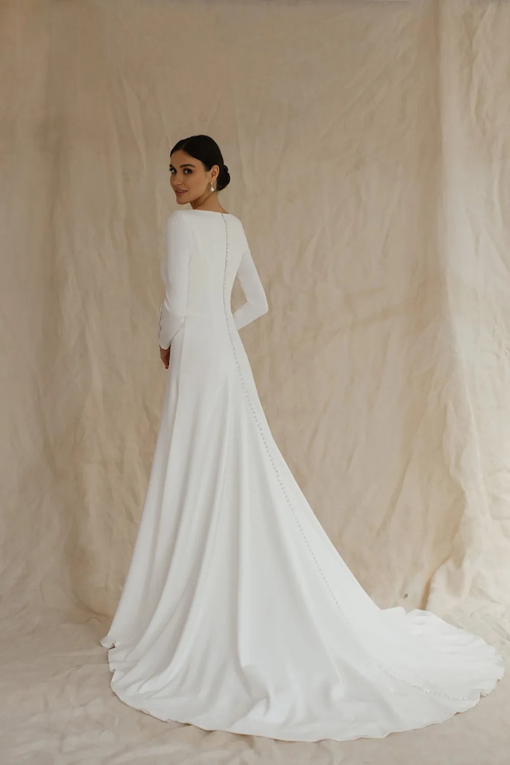 White A-line wedding dress back view with long sleeves and flowing train