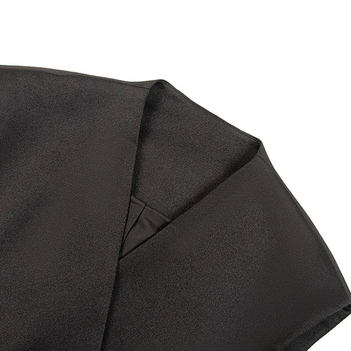 Close-up of black tailored peplum vest fabric and draped front panel