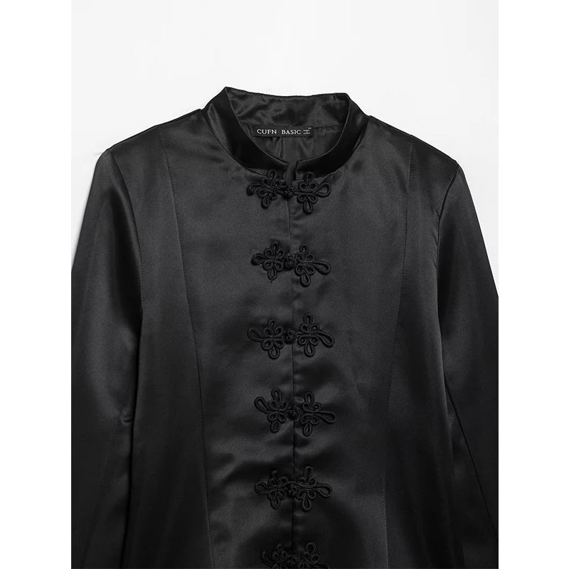 Black satin stand-collar blazer close-up with embroidered floral button placket