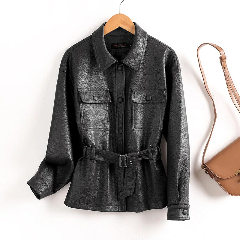 Black leather women’s coat with pointed collar, flap chest pockets, waist belt, button cuffs