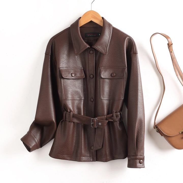 Brown leather women’s coat with pointed collar, flap chest pockets, waist belt, button cuffs