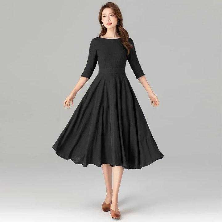Black midi dress with 3/4 sleeves, gathered skirt, and defined waist