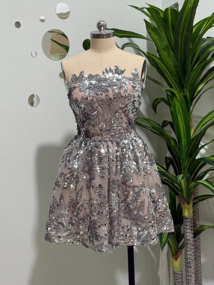 Silver sequin mini dress with fitted bodice and flared skirt on mannequin