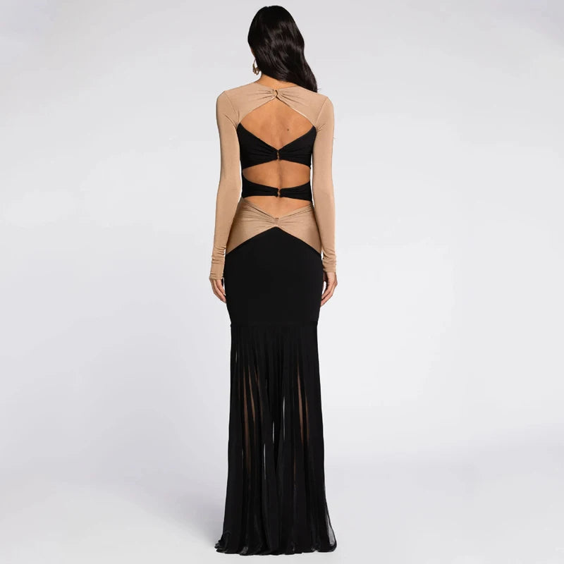 Model wearing a two-tone dress with open back and fringe details on a white background.