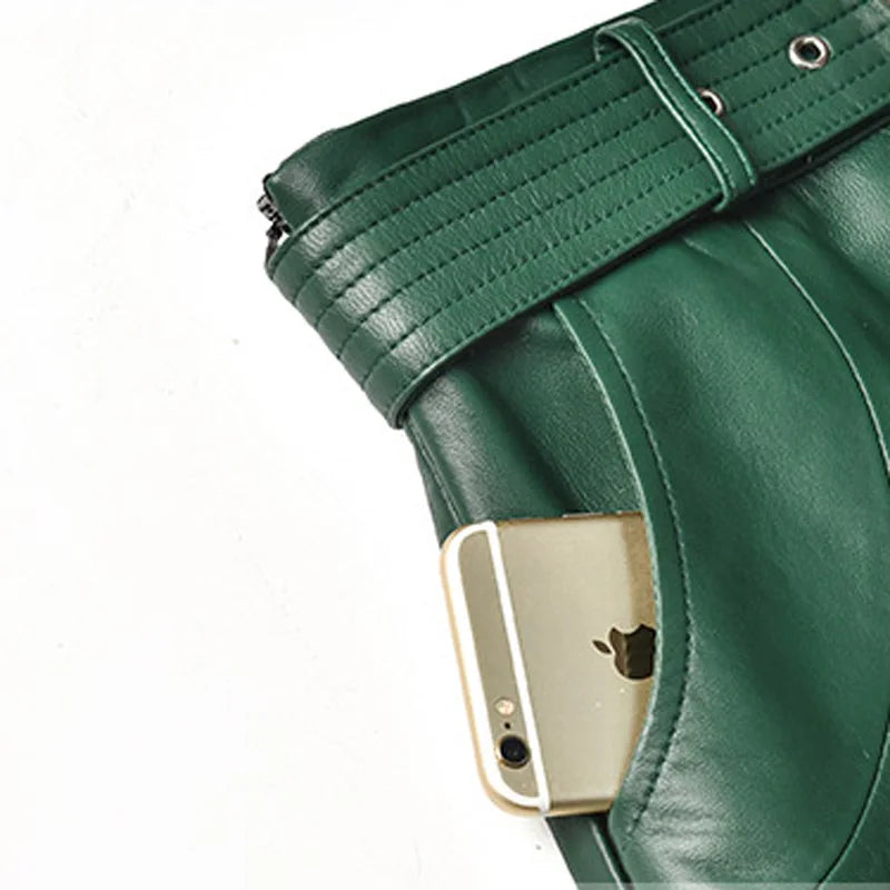 Green leather skirt waistband close-up with belt buckle and eyelets