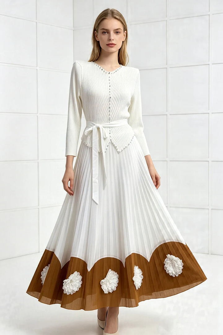 White pleated midi party dress with long sleeves, tie waist, scalloped pom hem with floral accents.