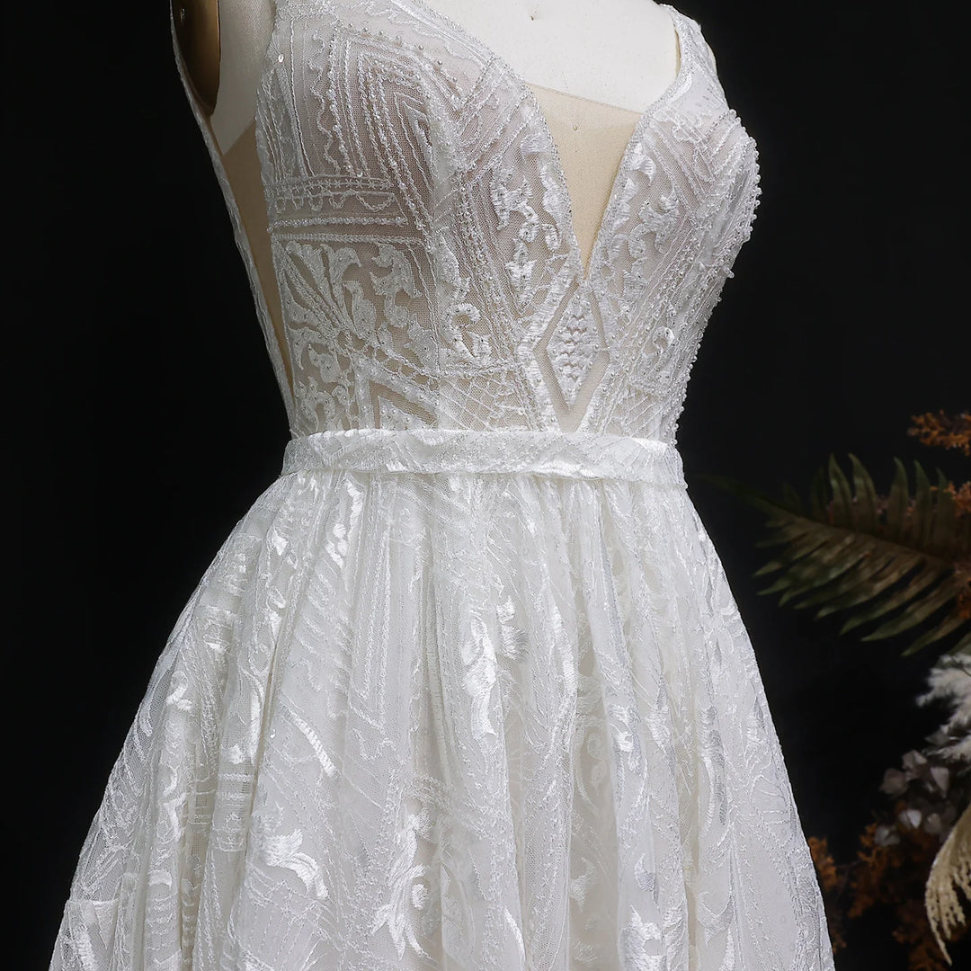 Close-up of off-white bridal gown bodice with embroidered V neckline and waist ribbon