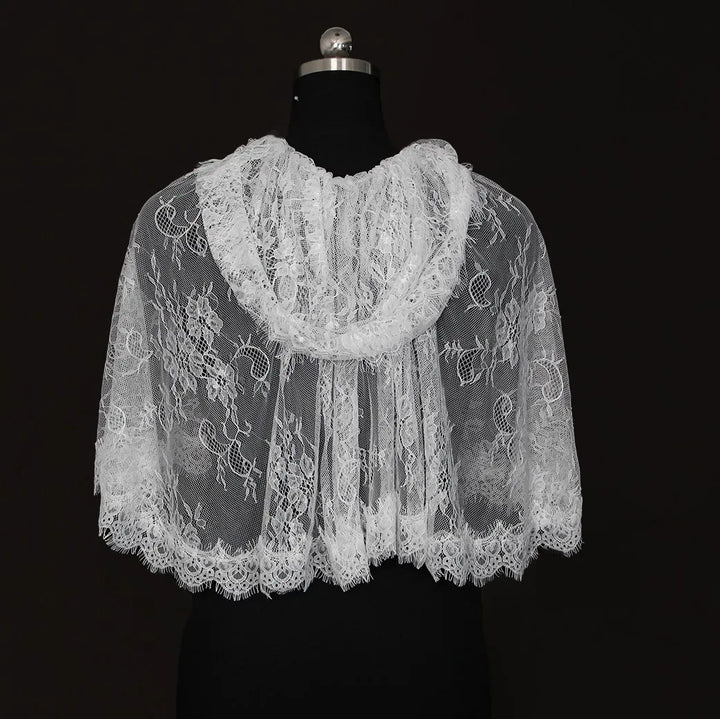 Off-white lace hooded cape on mannequin, back view with floral patterns and scalloped border