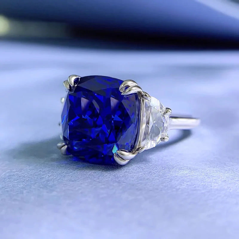 Sterling silver ring featuring a large blue center stone with prong-set clear accents