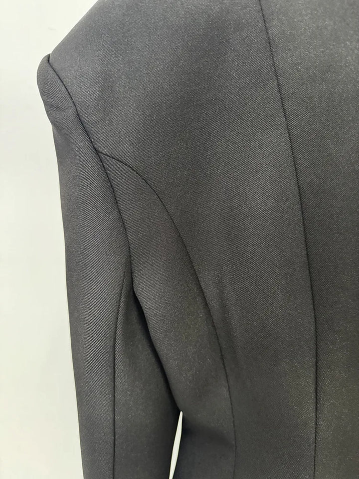 Black blazer fabric close-up with curved seam and structured paneling