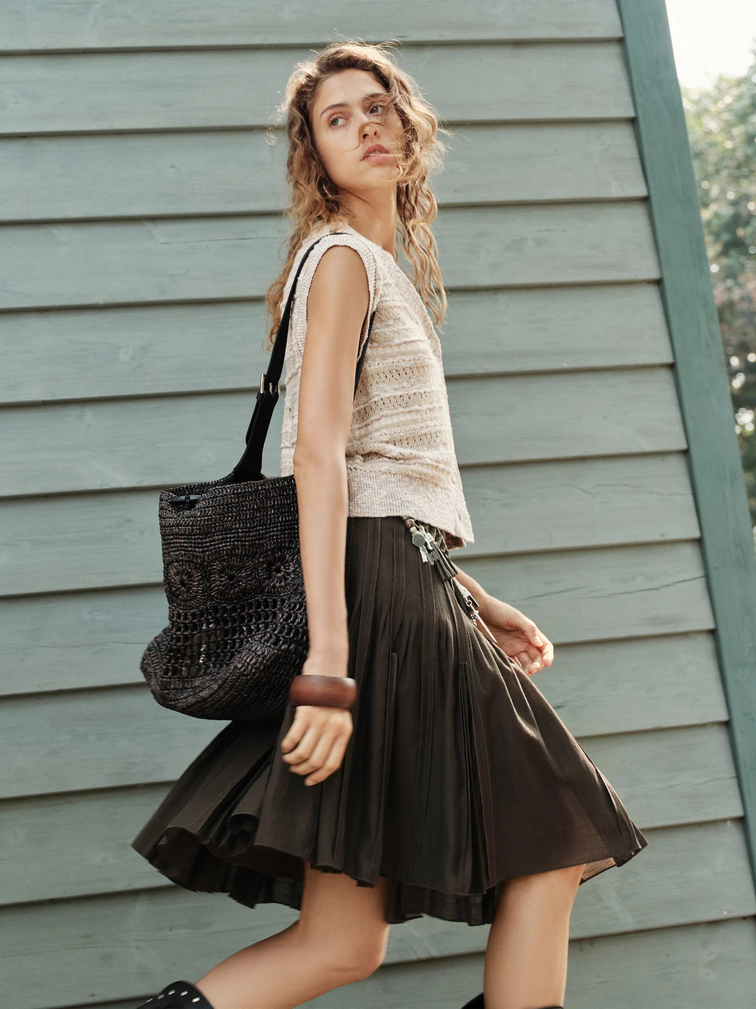 Dark brown pleated mini skirt with elastic waist, flared silhouette, side drape