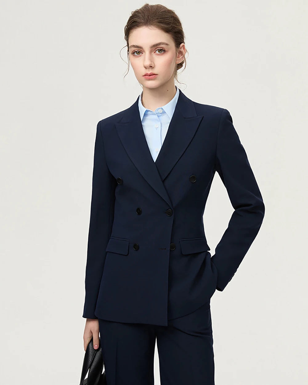 Navy two-piece blazer suit with notched lapels, white V-neck blouse, straight-leg pants