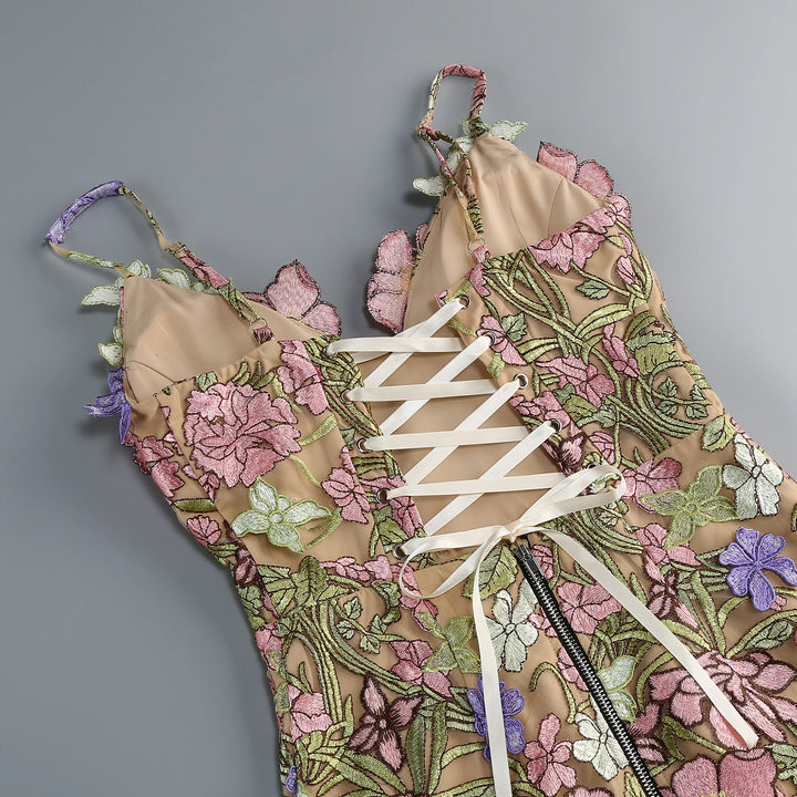 Close-up of floral embroidered mini gown with lace-up corset detail and sheer underlay.