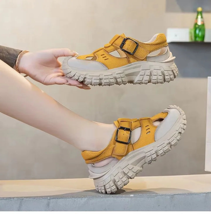 Yellow chunky sandals shown from side with buckle-style strap and thick tread