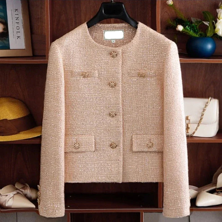 Beige tweed jacket on a hanger with a wooden shelf background