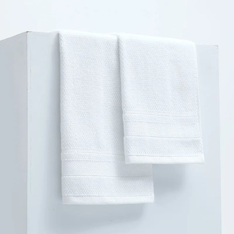 White cotton face towels, neatly stacked with rolled edges