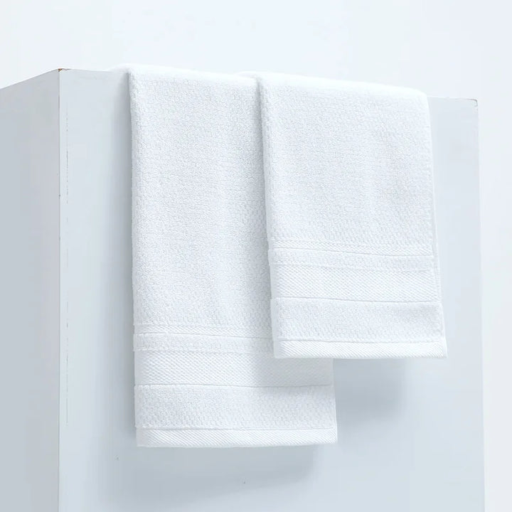White cotton face towels, neatly stacked with rolled edges