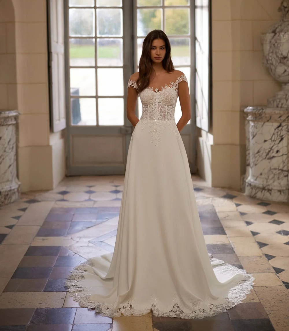 White women’s wedding dress with lace bodice, beaded sleeves, and full flowing skirt