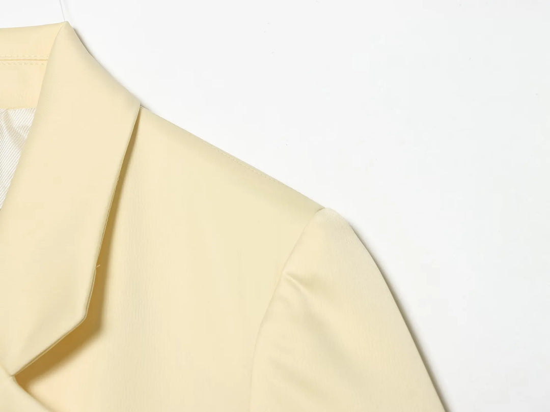 Beige cropped satin blazer jacket shoulder and lapel close-up with crisp seams
