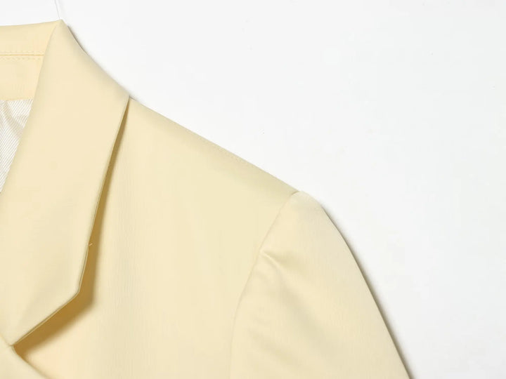 Beige cropped satin blazer jacket shoulder and lapel close-up with crisp seams