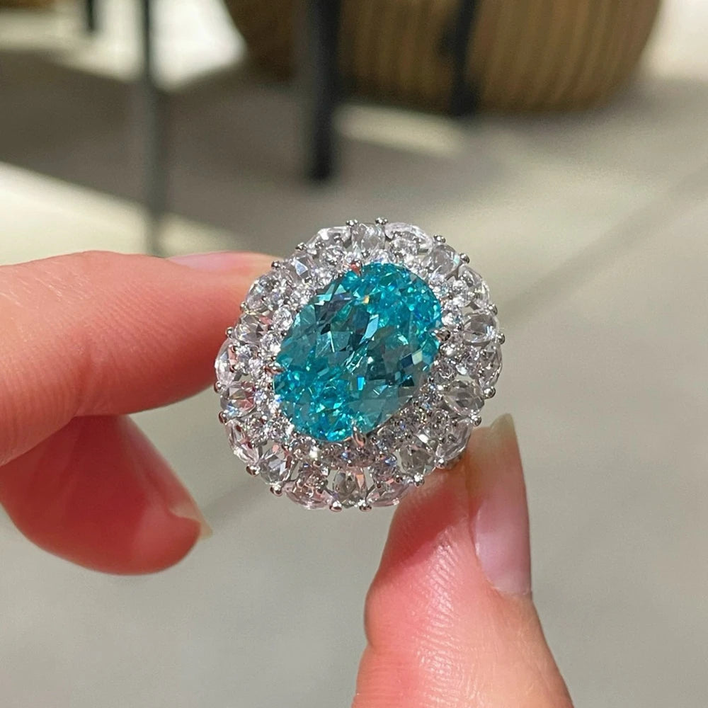 Sterling silver oval gemstone halo ring, blue-teal center with clear crystal halo