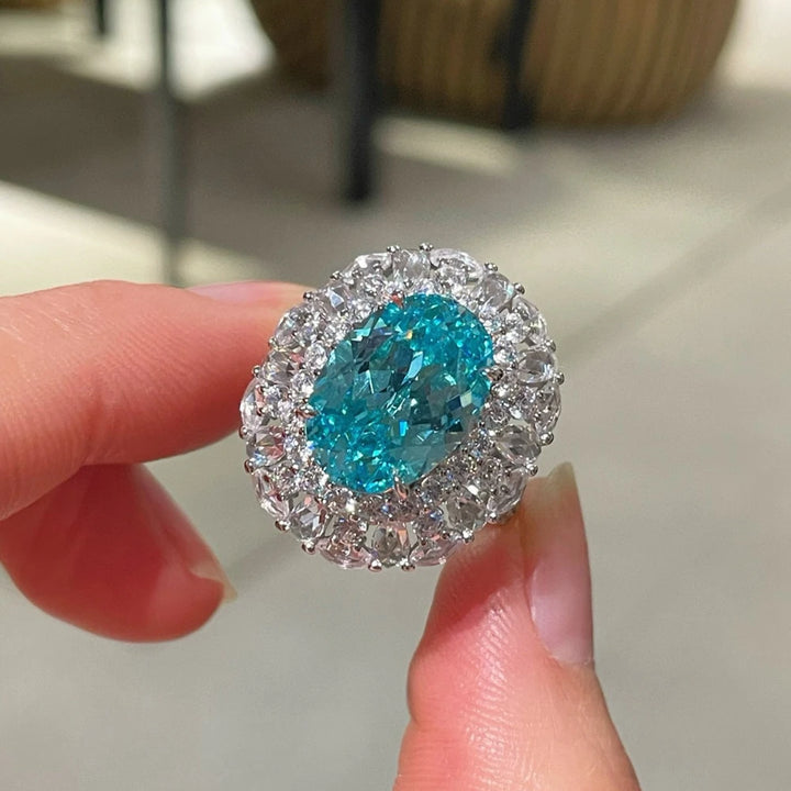 Sterling silver oval gemstone halo ring, blue-teal center with clear crystal halo