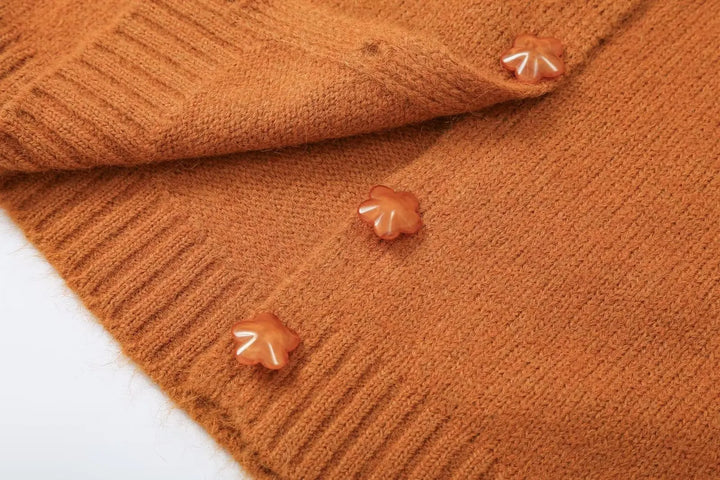 Orange knit cardigan side close-up with three small star-shaped buttons