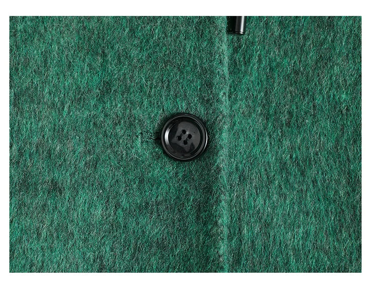 Green wool-blend coat chest close-up with black round button
