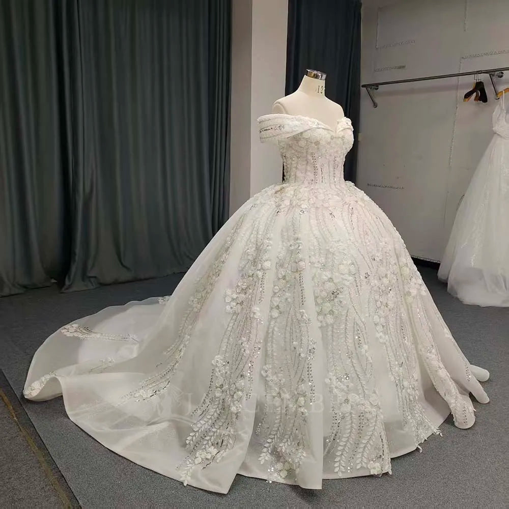 White lace bride dress with V-back and beaded floral pattern, flowing full skirt