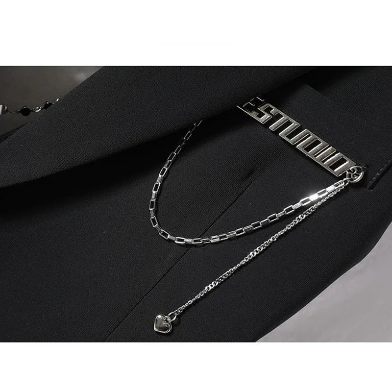 Black suit waistcoat fabric with silver-toned chain necklace and charm detail