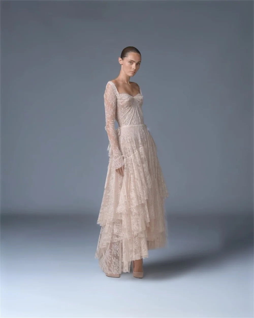 Ivory lace bridal gown with fitted bodice and tiered skirt, long sleeves