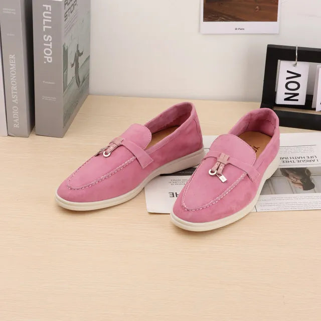 Pink suede slip-on loafers with metal buckle and moc toe stitching
