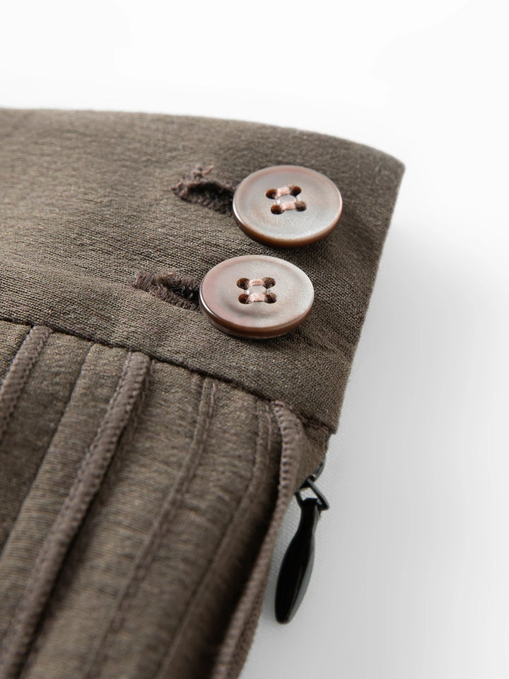 Dark brown skirt waistband with two-button detail and stitched pleat construction