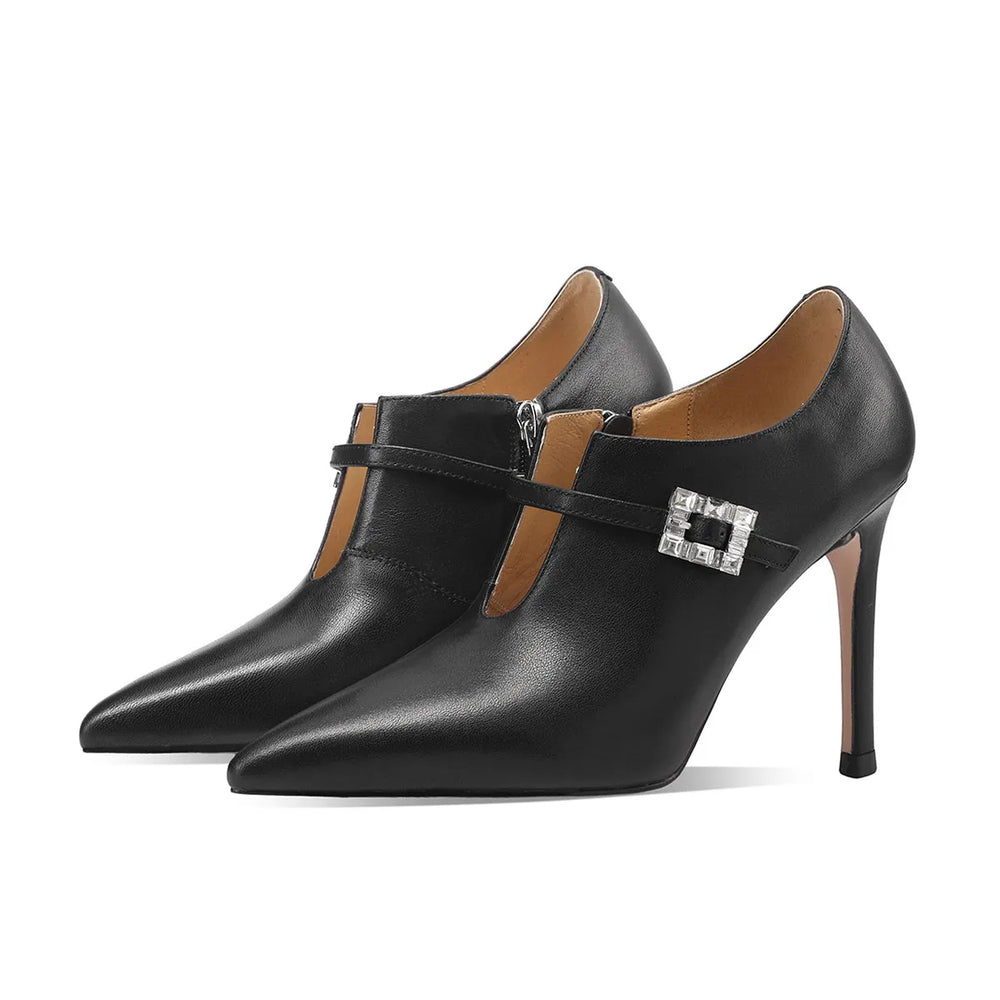 Pair of black pointed-toe pumps with stiletto heels and silver buckle strap