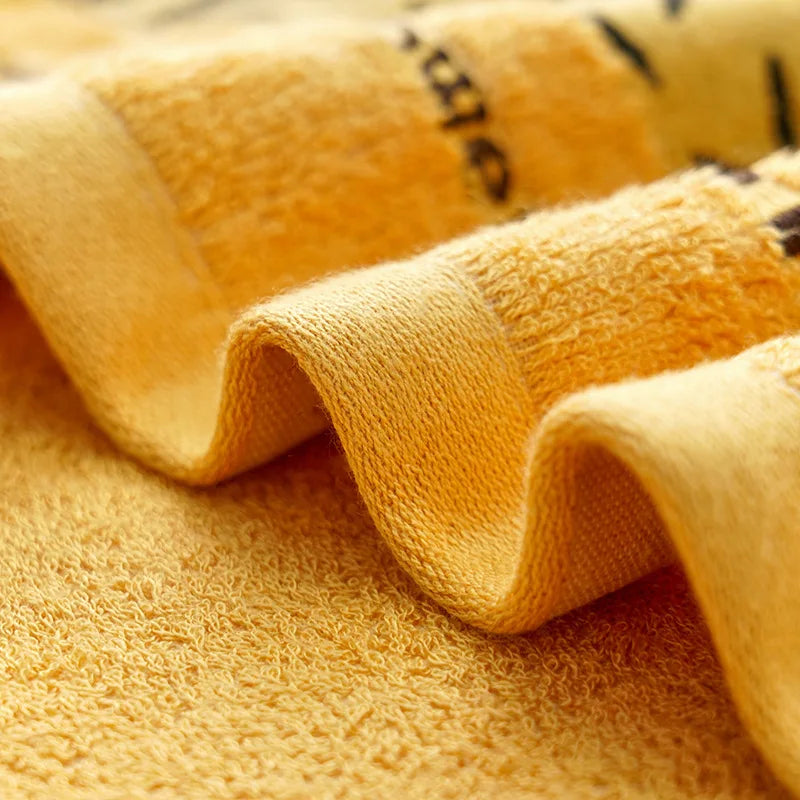 Golden yellow bathroom towels with textured terry loops and folded edge detail