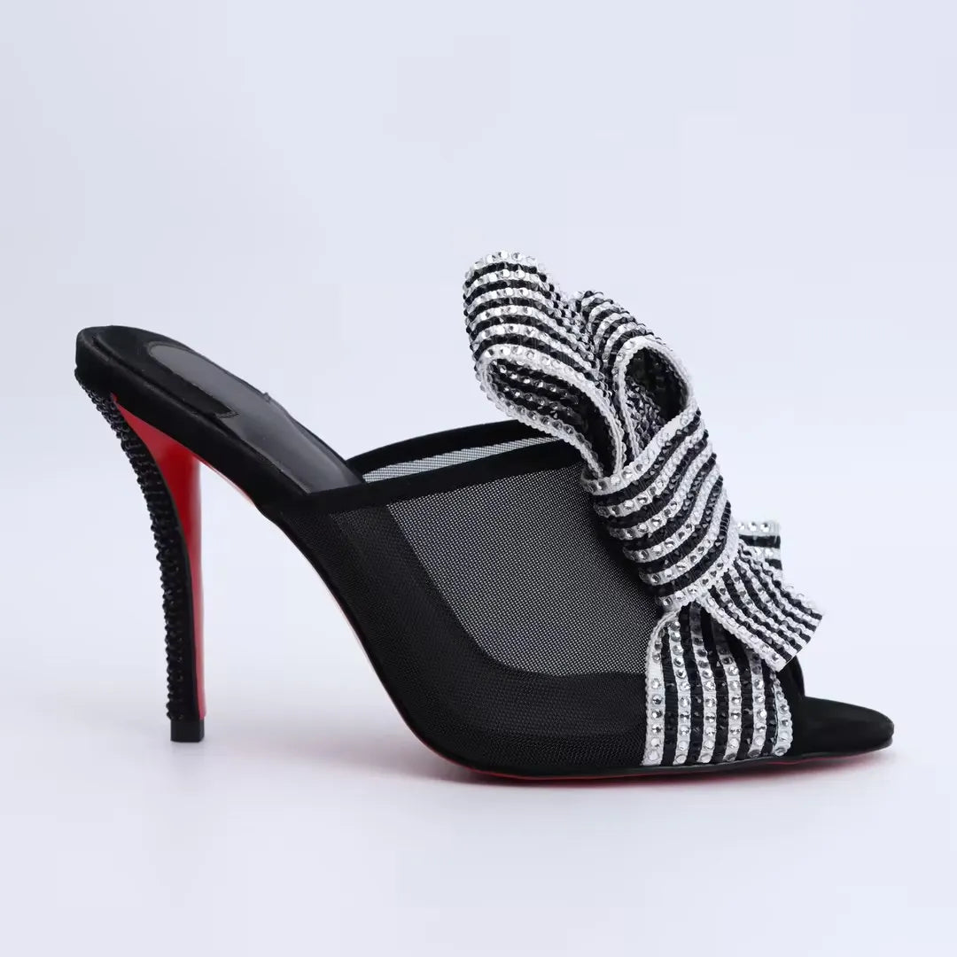 Side-view black high-heel mule sandals with rhinestone-striped mesh bow strap and open toe