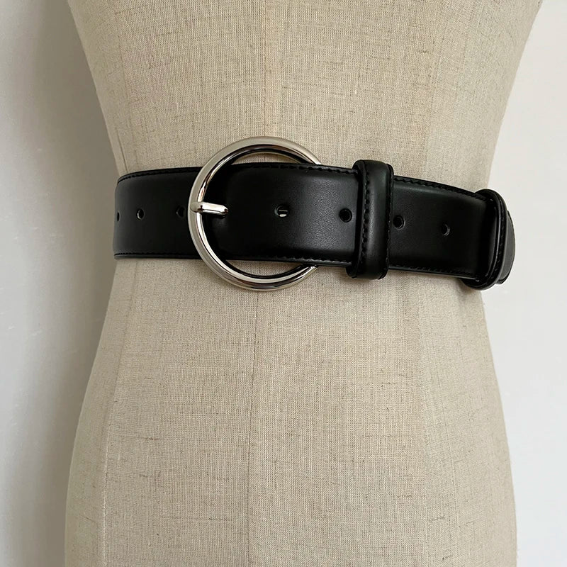 Black wide leather corset belt with oval metal buckle ring and punched adjustment holes