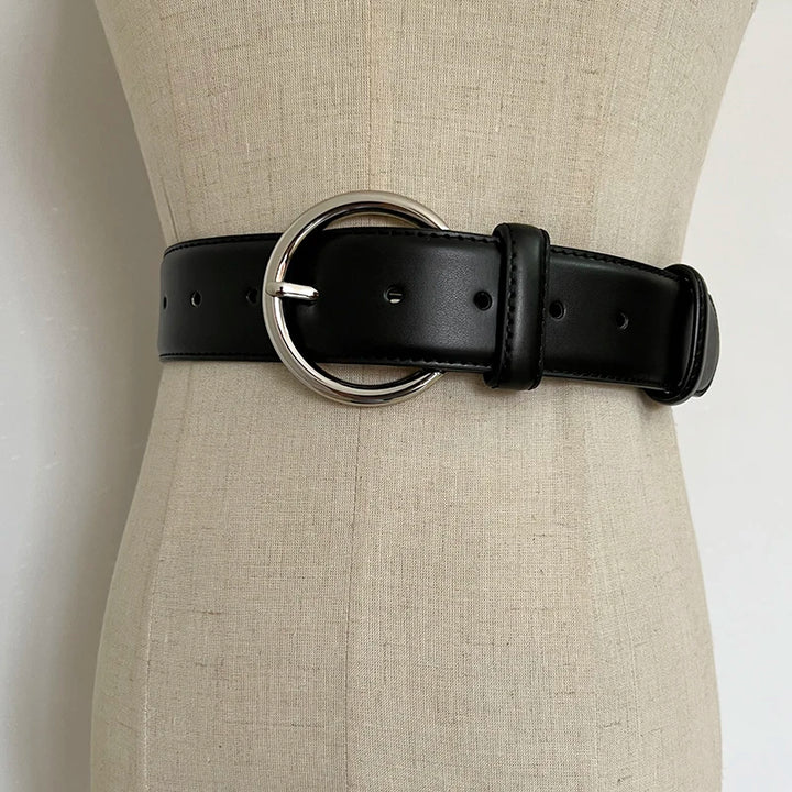 Black wide leather corset belt with oval metal buckle ring and punched adjustment holes