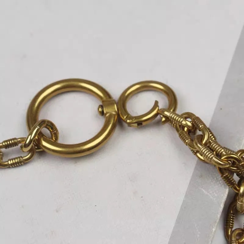 Gold metal chain belt clasp close-up with round rings and small hook detail