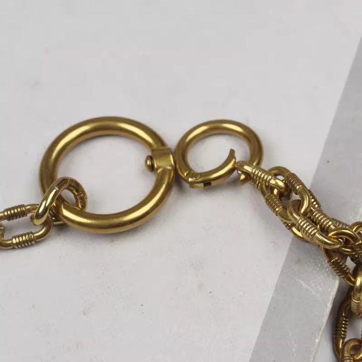 Gold metal chain belt clasp close-up with round rings and small hook detail