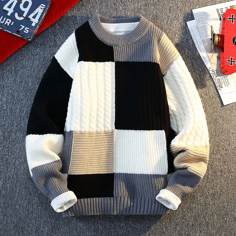 Patchwork knit sweater with black, white, light gray, and beige blocks; ribbed collar.