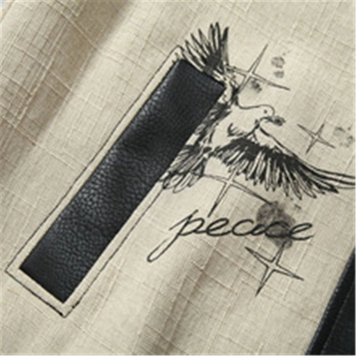 Cream patchwork panel with printed graphic on a black leather varsity baseball coat