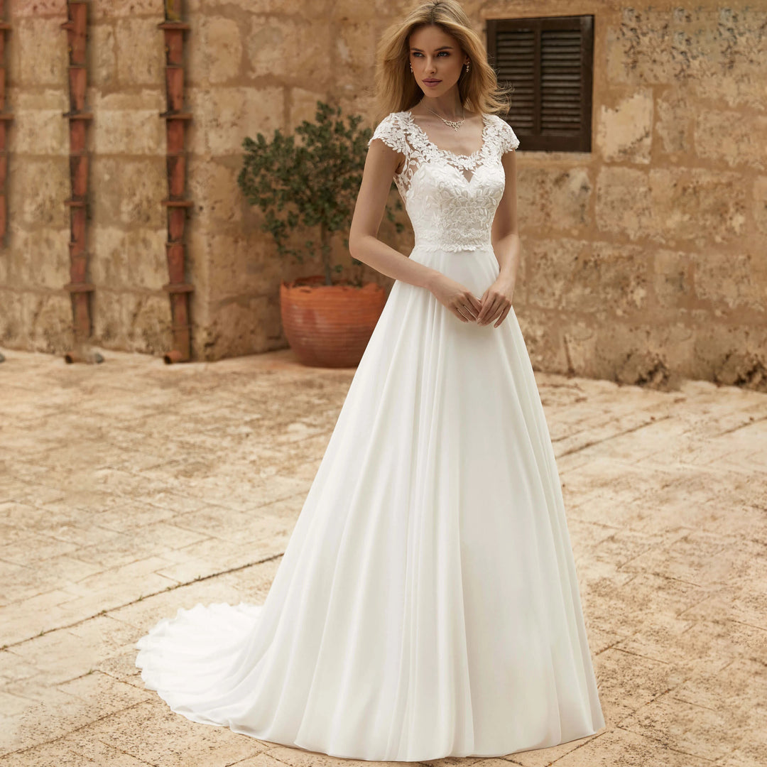 Ivory lace bodice chiffon A-line bridal gown with cap sleeves and scalloped V neckline