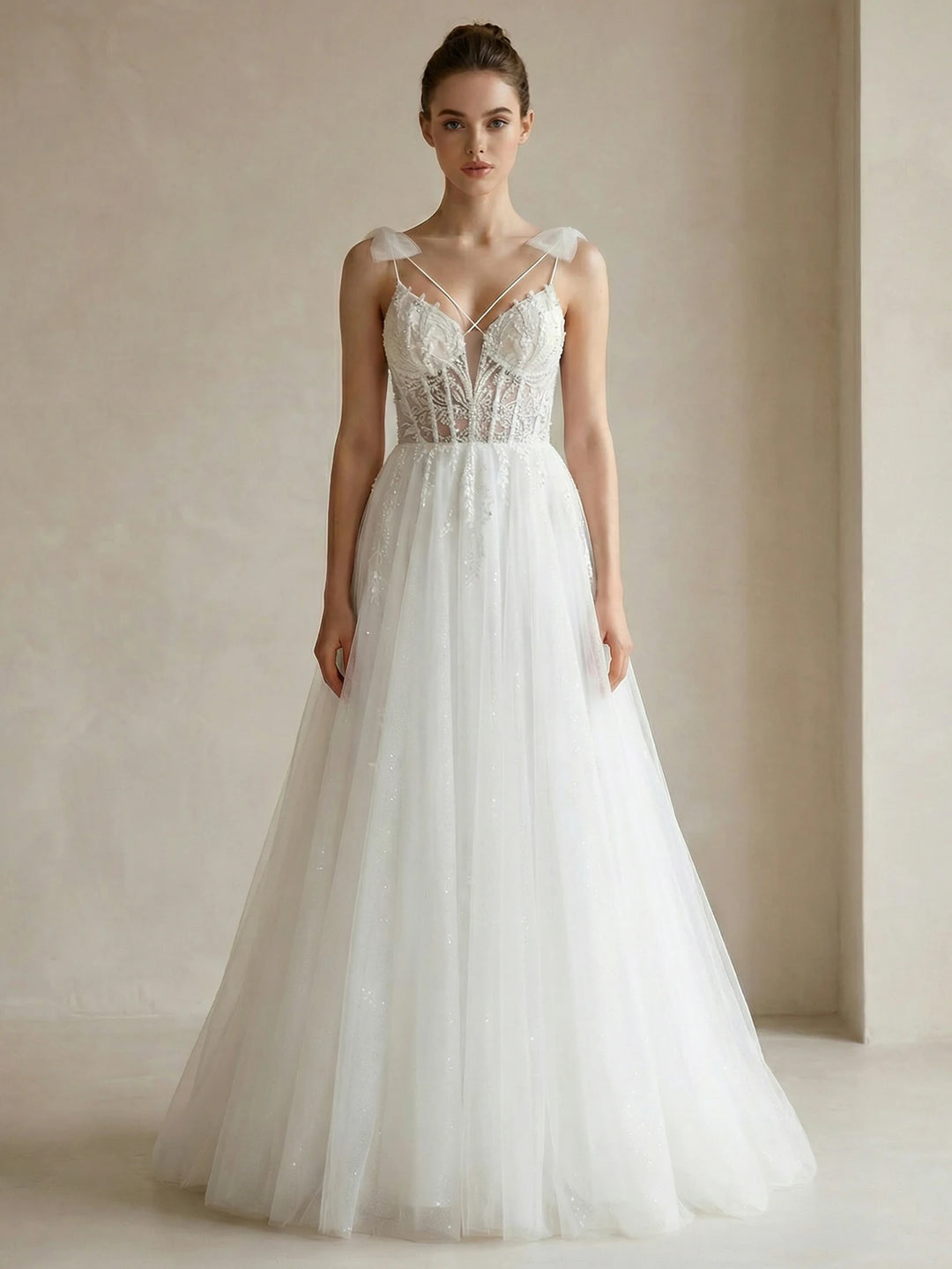 White beaded bridal gown with corset bodice and spaghetti straps, A-line tulle skirt